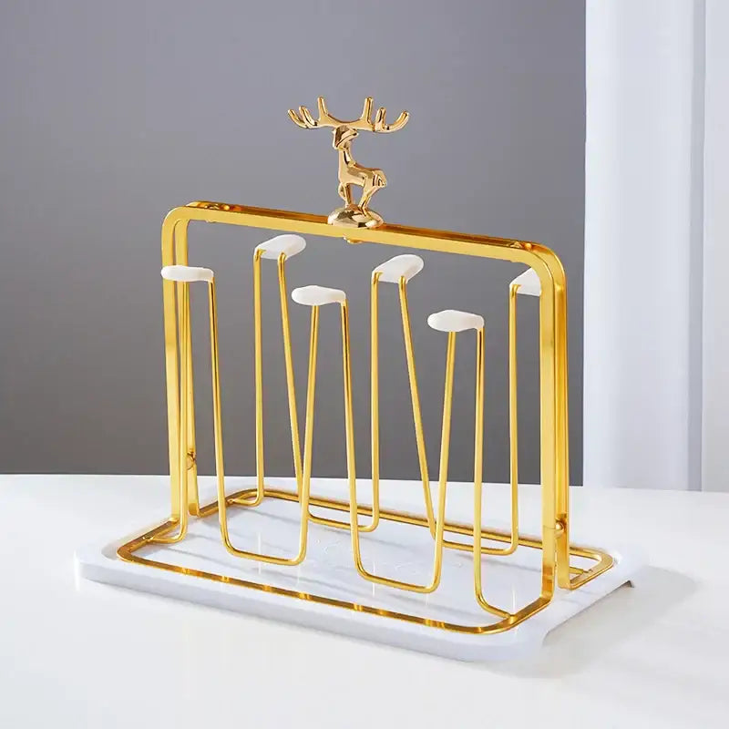 Gold-toned metal cups holder set with marble base and decorative reindeer figurine for drying and display