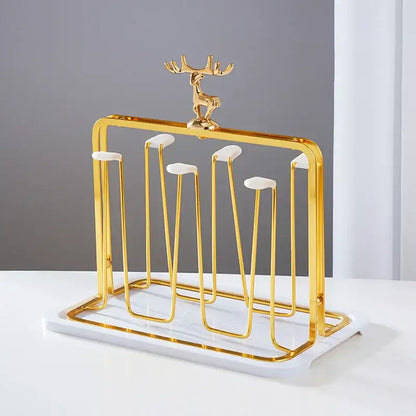 Gold-toned metal cups holder set with marble base and decorative reindeer figurine for drying and display