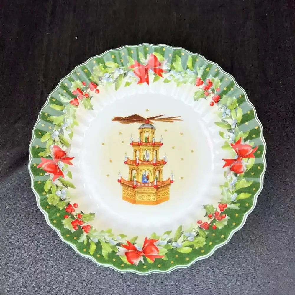 A festive ceramic plate from DecorBites Christmas tableware featuring a golden pagoda with red bows and holly berries