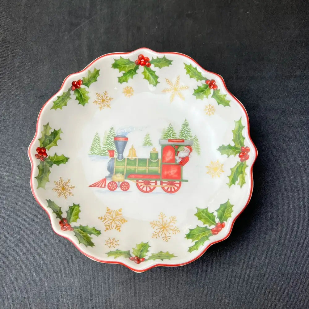 A festive white ceramic bowl with scalloped edge and santa train design from decorbites christmas tableware