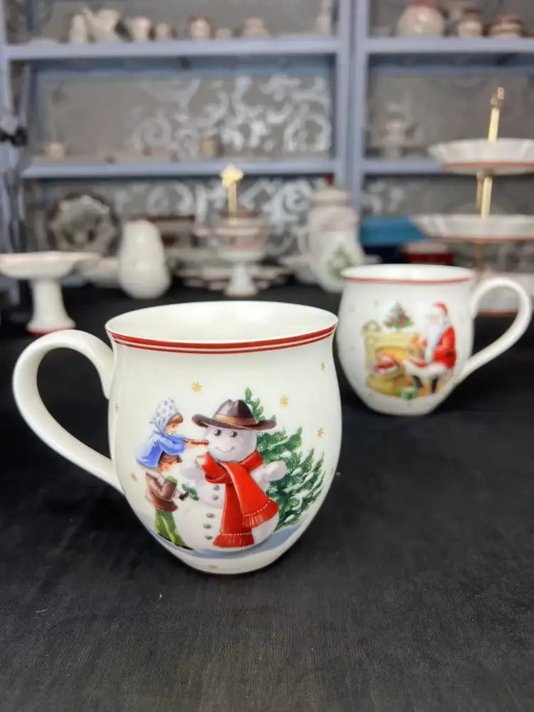White ceramic mug with red rim and festive children building snowman illustration from decorbites christmas tableware set