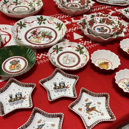 White ceramic decorbites christmas tableware featuring santa claus reindeer trains and holly motifs in red green accents
