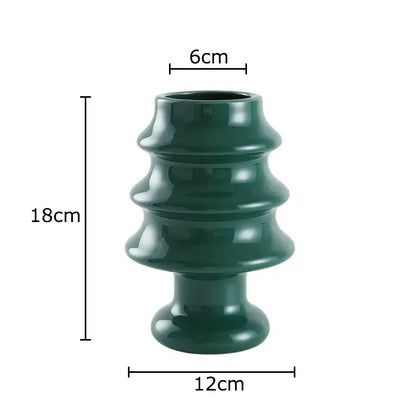 A sleek dark green ceramic vase with tiered design from decorbites christmas tree collection for holiday room decor