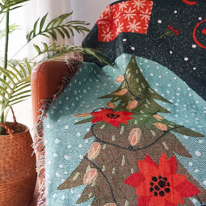 A cozy teal decorbites christmas tree knitted throw blanket with red poinsettias snowflakes and fringed edges