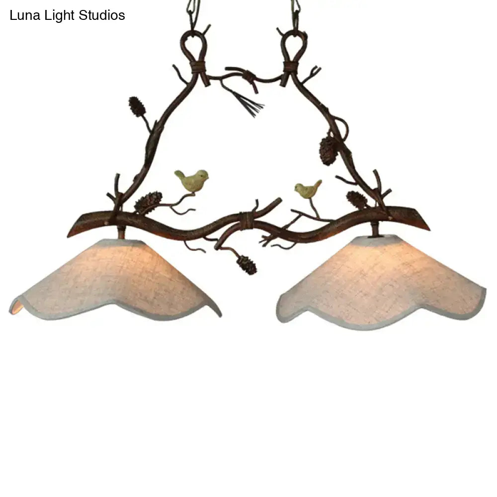 Rustic bronze resin branch suspension light with two warm glass scalloped shades and yellow bird figurines with pinecones