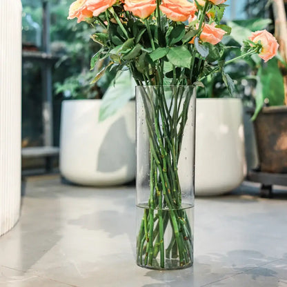 Clear acrylic cylinder vase by DecorBites holding peach-colored roses for weddings in a clear acrylic design