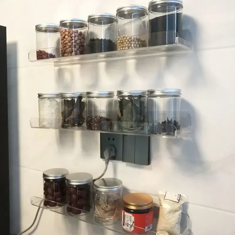 Decorbites clear acrylic wall mounted shelf organizer with clear glass spice jars and silver lids neatly arranged