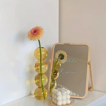DecorBites™ clear glass bubble vase in amber with stacked spheres holds a pink and yellow gerbera daisy for home decor