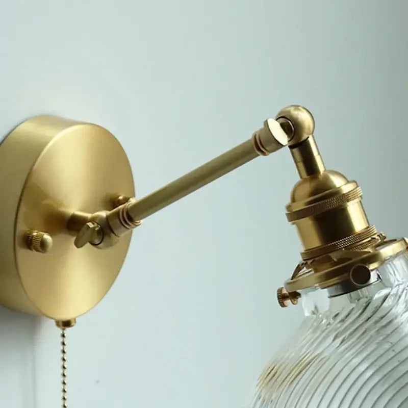 Brass-finished adjustable wall sconce with ribbed decorbites clear glass led shade for dining room lighting