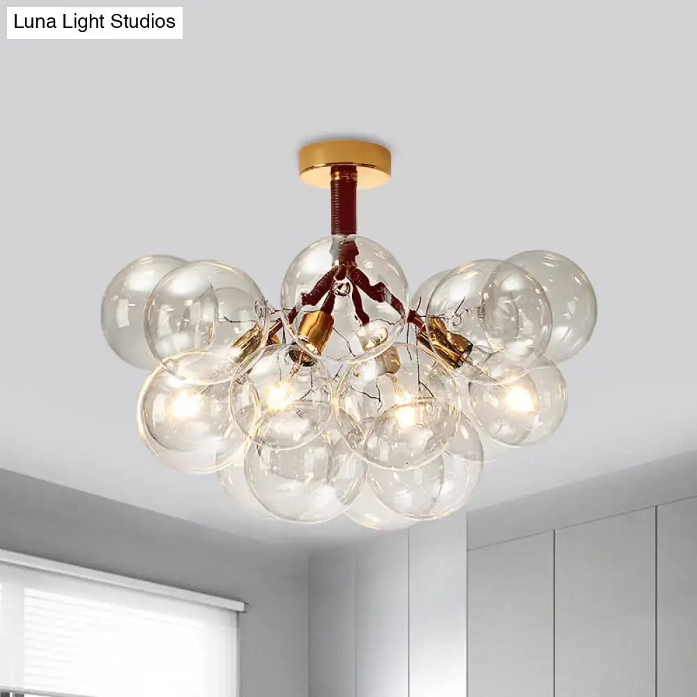 Modern glass bubble semi flush ceiling light with brass accents and exposed filament bulbs for foyer illumination