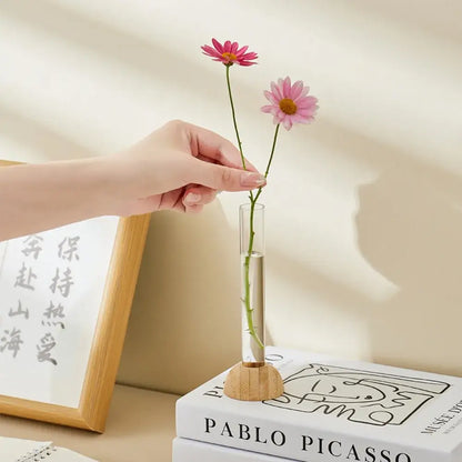 Decorbites clear plastic test tube vase with wooden base holding two pink daisies for home decor