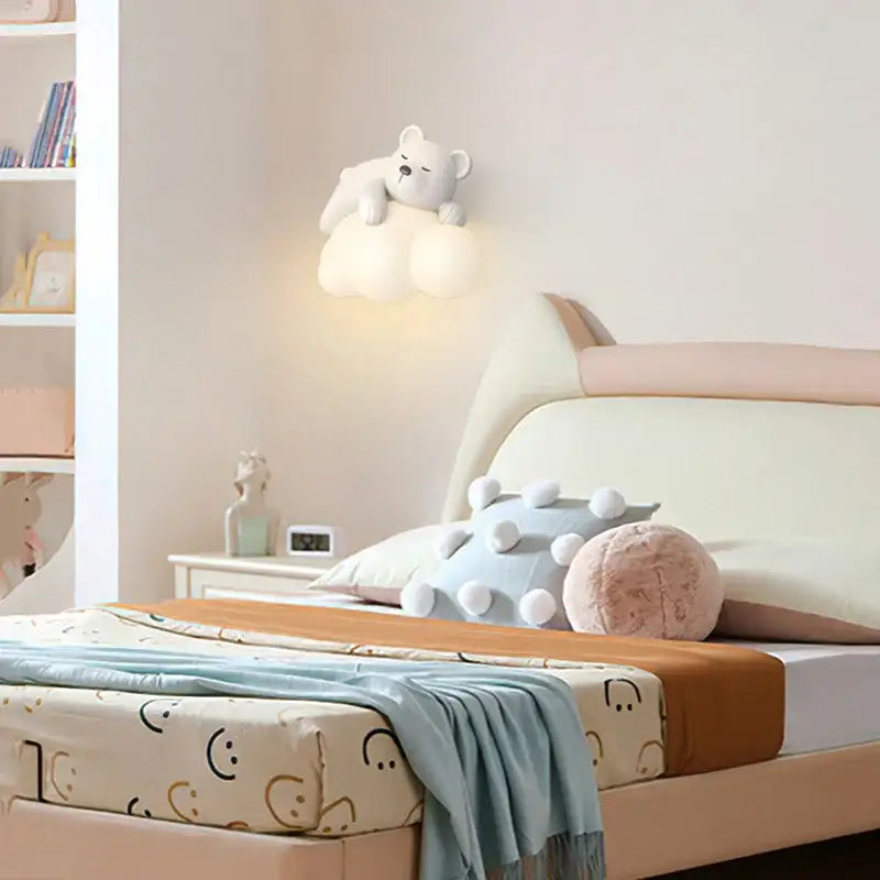 A soft white ceramic decorbites cloud bunny wall lamp shaped like a sleeping bear on a cloud for bedroom lighting