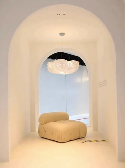 Cream-colored plush cushioned lounge chair with soft fabric upholstery complementing decorbites cloud chandelier bedroom light