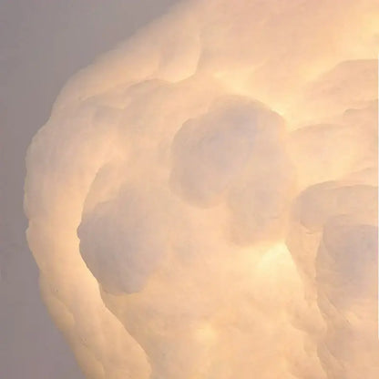 A soft glowing decorbites cloud chandelier made of silk cotton with warm diffused light for nursery decor