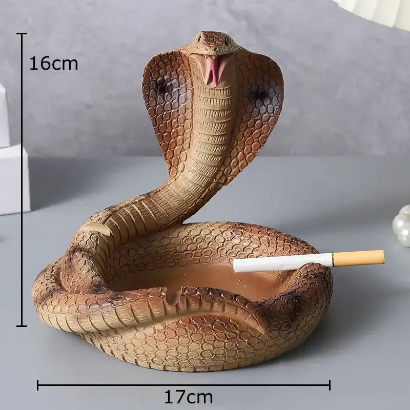 A detailed brown decorbites cobra ashtray made of orange resin with textured scales and an open mouth for cigarette use