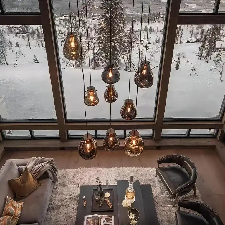 A set of seven amber pendant lights with copper accents in a decorbites colorful glass chandelier for dining rooms