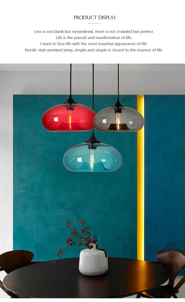 Three colorful glass colorful led pendant lights with black metal fixtures hang above a dining table for restaurant decor