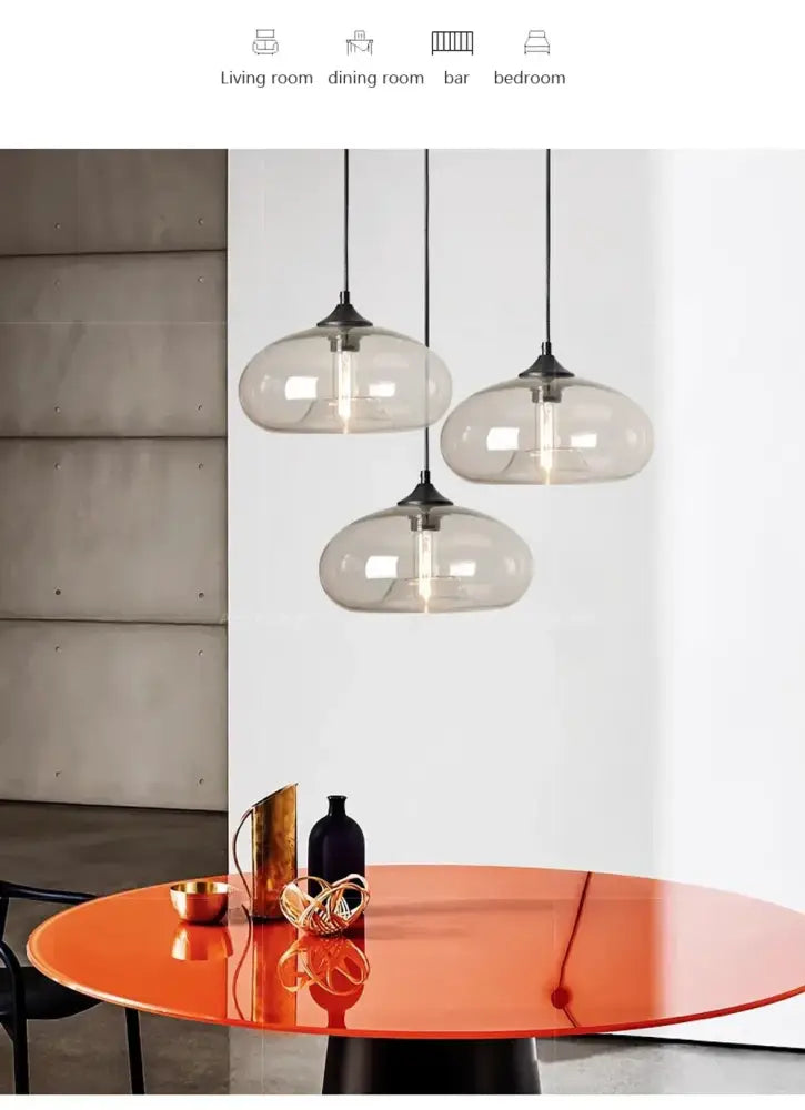 DecorBites colorful led pendant lights with smoke-gray glass globes and black metal fixtures above an orange table