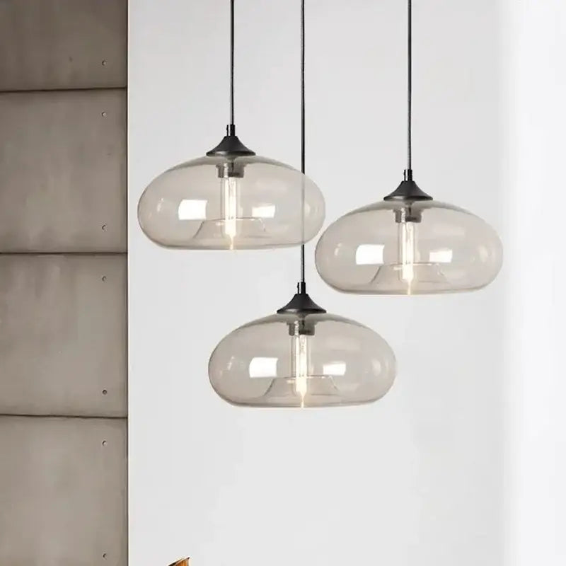 Three modern pendant lights with translucent gray glass shades and black metal fixtures for colorful LED decor