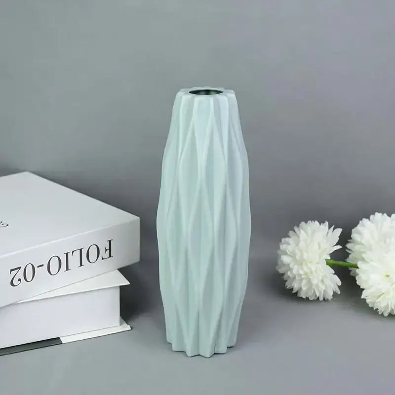 A sleek light mint-green ceramic modern flower vase with a geometrically faceted design for home décor