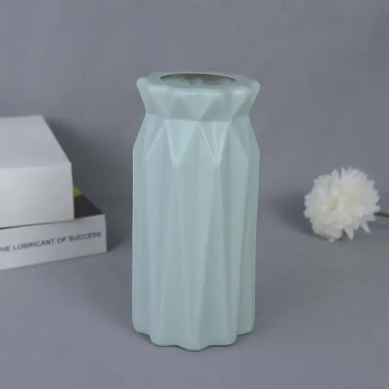 A sleek mint-green ceramic modern flower vase with geometric faceted design for home décor by DecorBites™