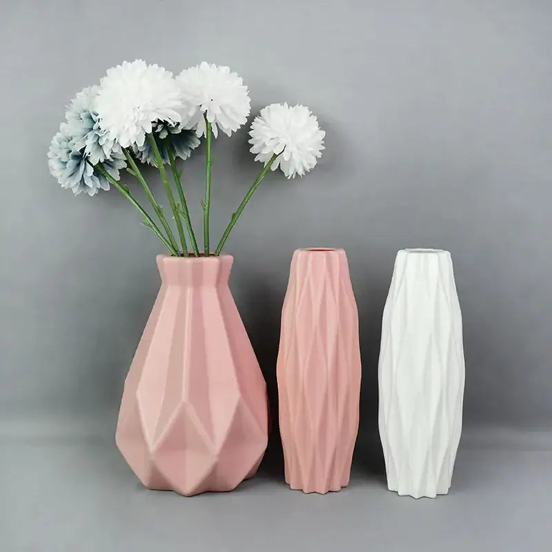 Three geometrically faceted soft pink and white colorful plastic flower vases with matte finish for modern home décor