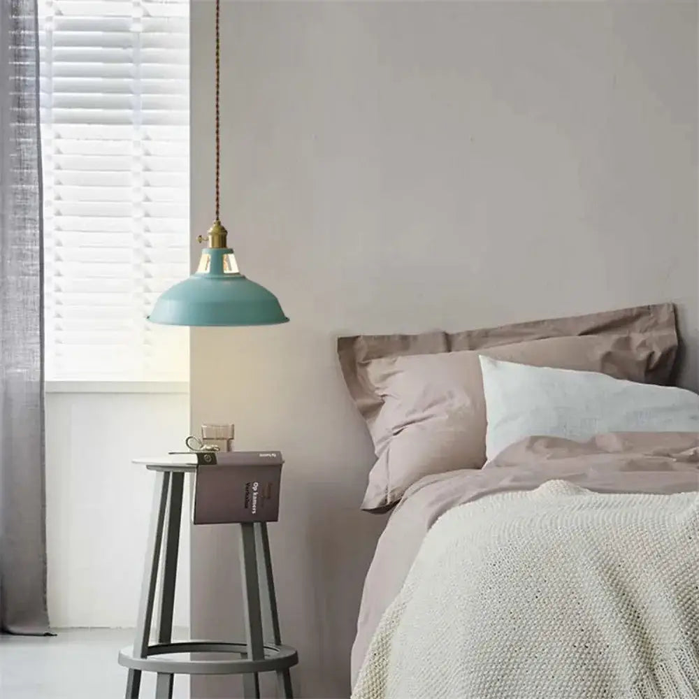 A teal colorful retro pendant light with a brass fixture hanging from a chain from DecorBites pendant lights