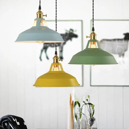 Three colorful retro pendant lights with brass fixtures and matte metal shades in blue olive green and mustard yellow