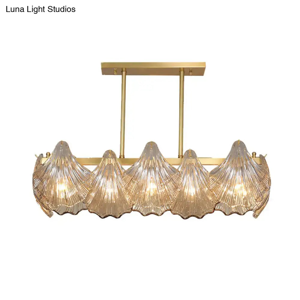 Gold-toned DecorBites™ pendant light with five amber crystal shades and brass island lighting linear metal arm design