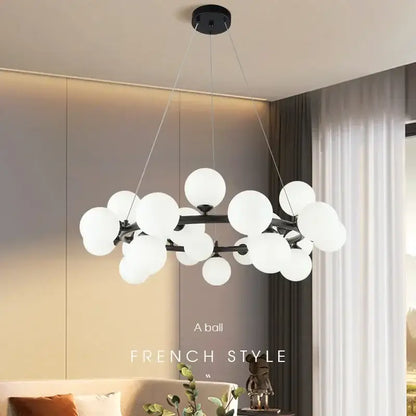 Modern black metal chandelier with clustered white glass ball globes in black and gold finish by decorbites