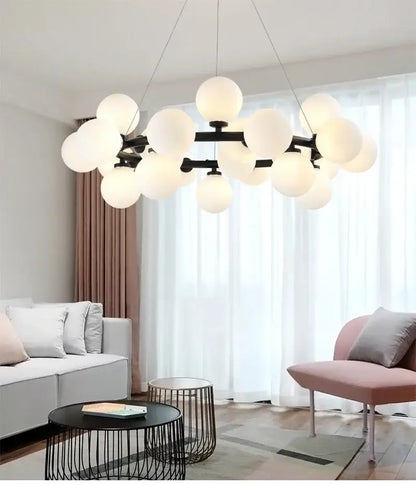 DecorBites contemporary black and gold chandelier featuring numerous frosted white glass ball globes