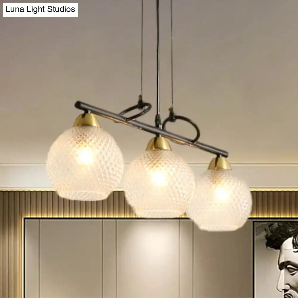 Modern three-light pendant fixture with frosted textured glass globes brass accents for dining hall with prismatic glass