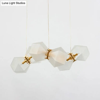 A modern decorbites frosted white glass honeycomb island lamp with brass ceiling hang and geometric faceted shades