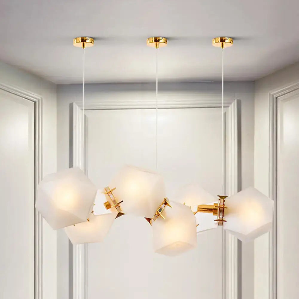 Modern geometric chandelier with frosted white glass shades and gold-toned metal arms in glass honeycomb island lamp design