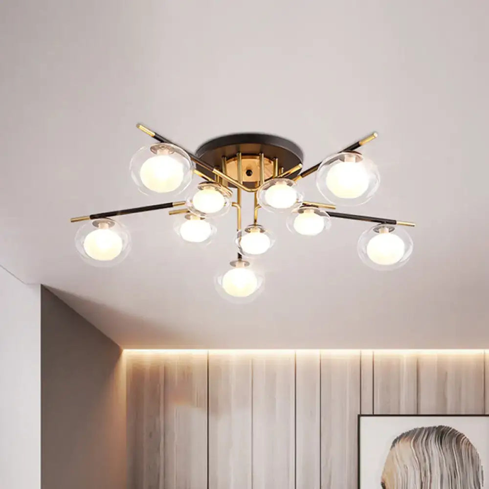 Modern semi-flush mount ceiling fixture with brass base black and gold arms and clear glass oval shade globes