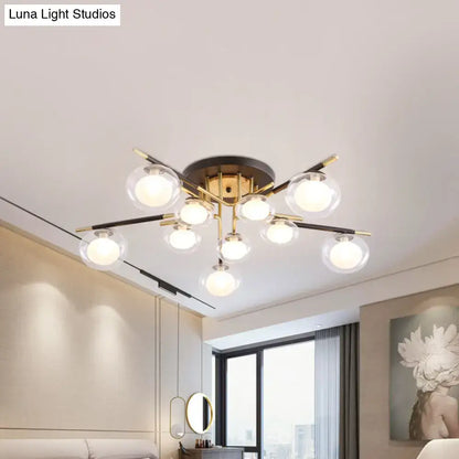 DecorBites™ contemporary semi-flush mount ceiling light with brass base, black and gold arms, and clear glass oval shade