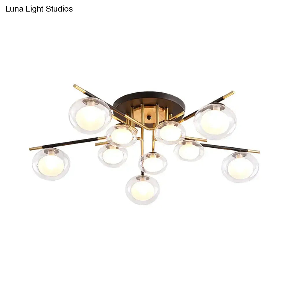 Modern semi-flush mount ceiling light with brass base black and gold arms and clear glass oval shade globes by DecorBites