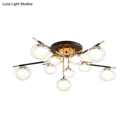Modern semi-flush mount ceiling light with brass base black and gold arms and clear glass oval shade globes by DecorBites