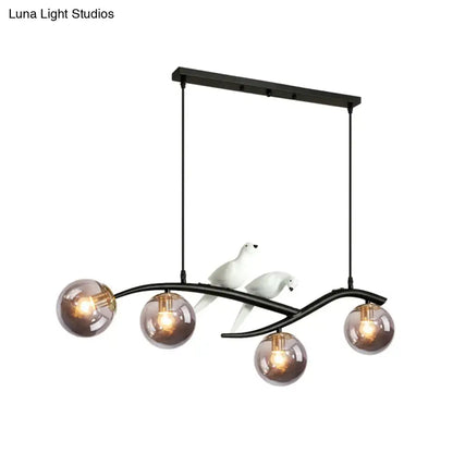 Black metal chandelier with smoke grey cognac glass shades and white ceramic bird decor for contemporary island lighting
