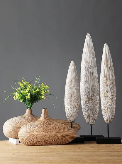 Set of three handcrafted wooden leaf sculptures with radial grain patterns displayed on black stands for contemporary resin vase décor