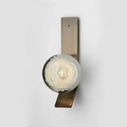 DecorBites™ contemporary wall light with brushed brass rectangular base and illuminated glass globe filled with bubbles