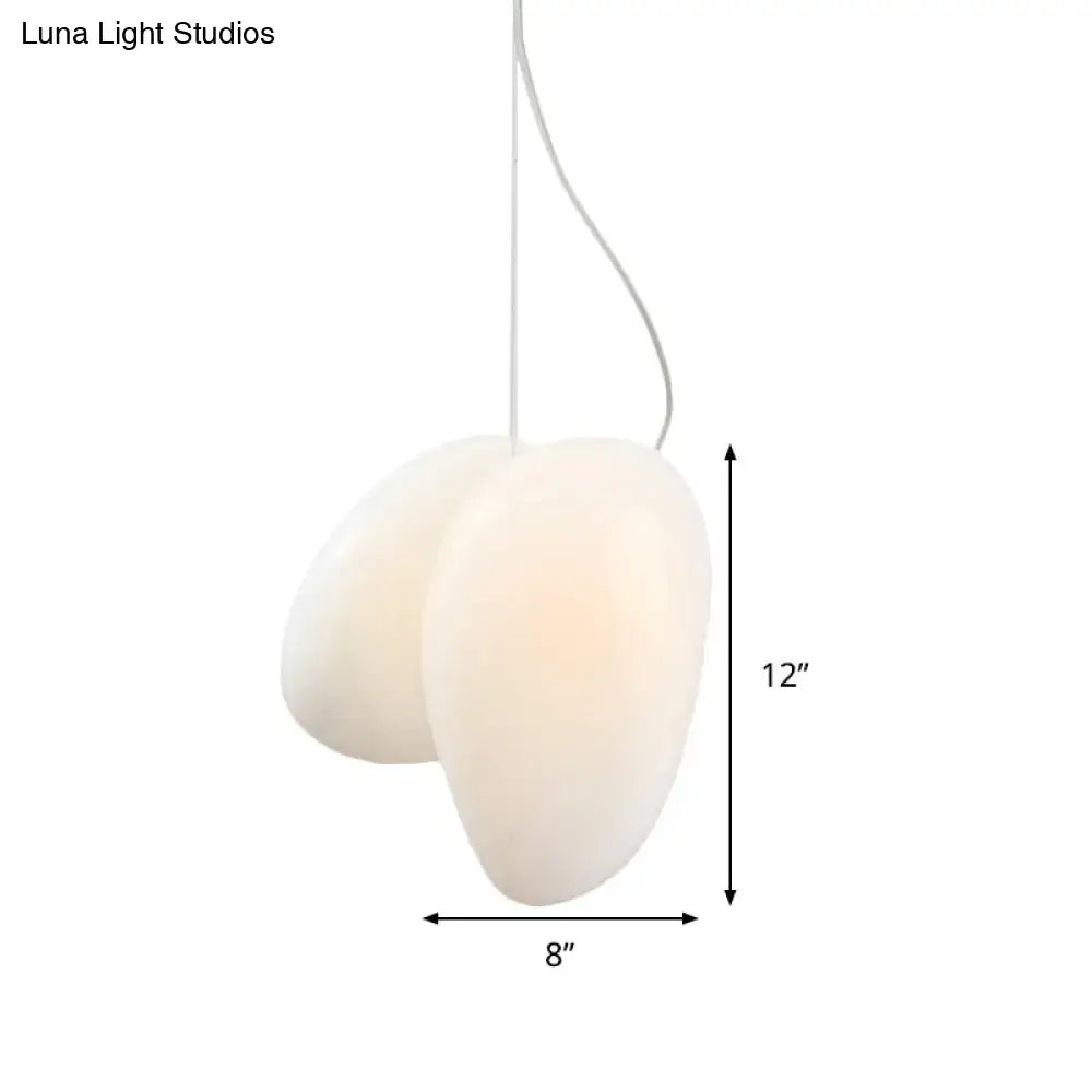 Cream-colored decorbites™ contemporary white glass pendant light with organic oval shape and white glass stacked cord suspension