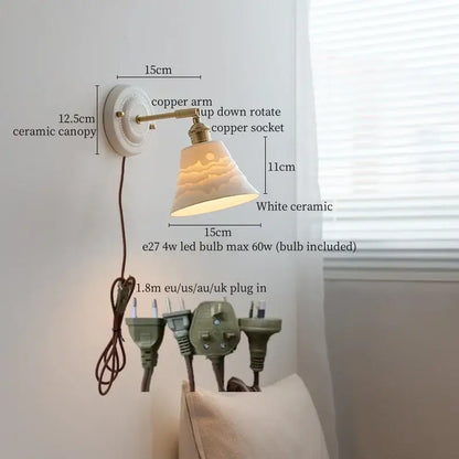 White ceramic wall lamp with decorbites copper arm and bell-shaped shade softly diffusing warm bedroom light