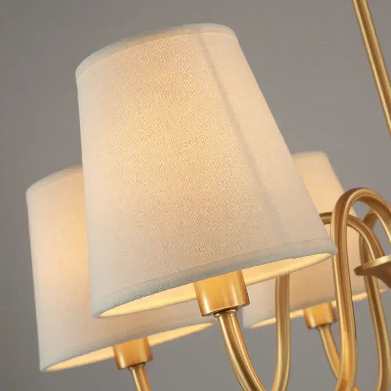 Cream-colored fabric lampshade with textured finish on polished brass arms in decorbites copper ceiling chandelier