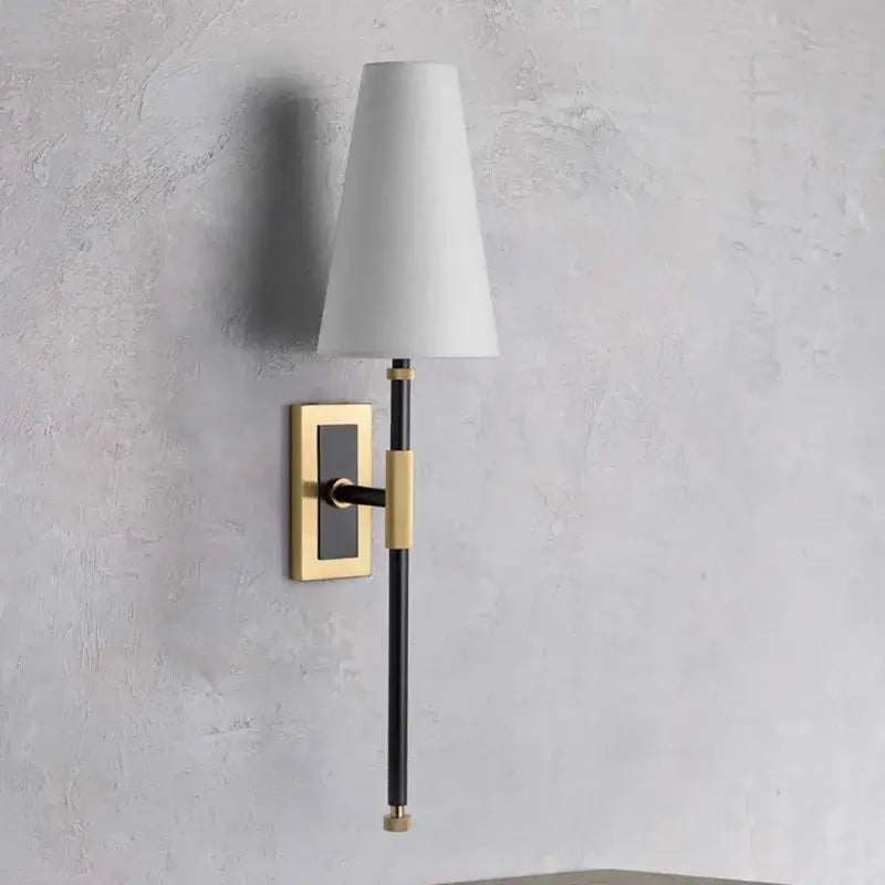 A sleek black and brass copper cloth led wall lamp with a white conical shade for bedroom reading