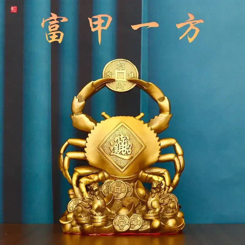 Golden copper crab ornament with intricate carvings and diamond-shaped fu character surrounded by coins and lion statues