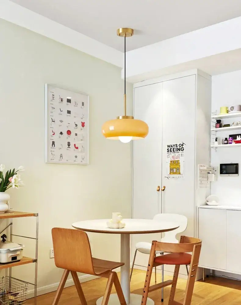DecorBites™ copper pendant light with warm yellow rounded glass shade and gold-toned metal hardware in modern design