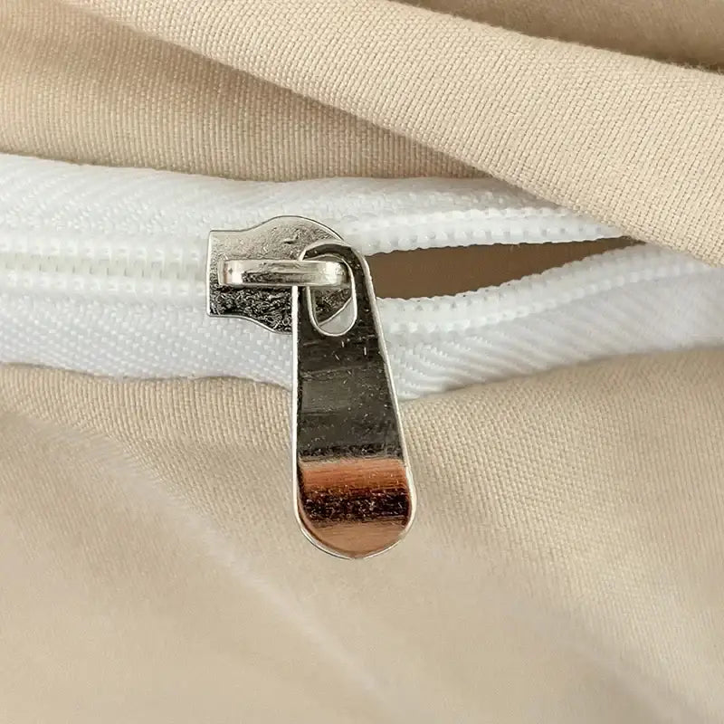 Silver-toned metal zipper pull with reflective finish on DecorBites™ cotton bedding set duvet cover