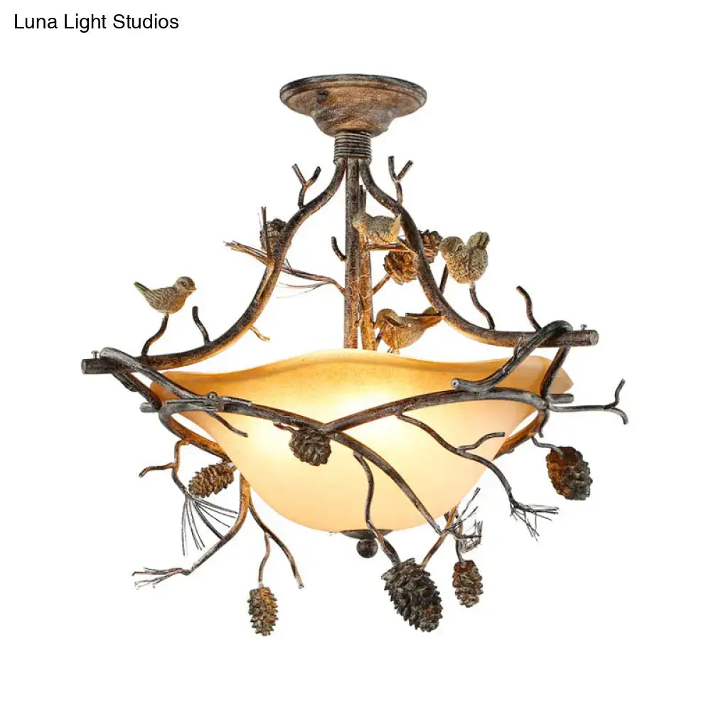 Rustic bronze metal bowl semi flush chandelier with amber glass shade and intricate branch pinecone details by decorbites