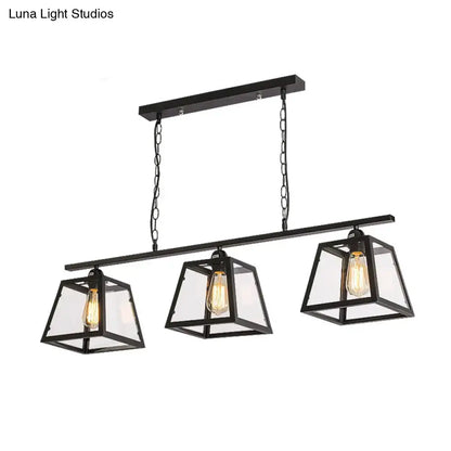 Black metal industrial island pendant light with three clear glass lanterns and exposed filament bulbs with chain cord length
